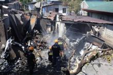 Les secours fouillent les décombres de la maison sur laquelle s'est écrasé un avion de tourisme, le 17 mars 2018 à Plaridel, aux Philippines