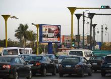 Dans une rue du Caire des voitures passent devant un panneau affichant la photo du président égyptien Abdel Fattah al-Sissi, candidat à sa réélection et assuré de l'emporter, le 22 janvier 2018