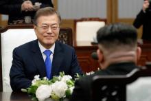Moon Jae-in (d) parle avec Kim Jong Un (de dos) pendant le sommet intercoréen, le 27 avril 2018 à Panmunjom