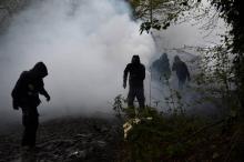 Des manifestants traversent un nuage de gaz lacrymogène lors de heurts avec les forces de l'ordre à la ZAD de Notre-Dame-des-Landes (Loire-Atlantique), le 14 avril 2018