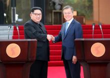 Le président sud-coréen Moon Jae-in (d) et le leader nord-coréen Kim Jong Un se serrent la main après avoir fait une déclaration commune lors du sommet interncoréen, le 27 avril 2018 à Panmunjom