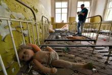 Un touriste prend des photos dans une école maternelle abandonnée dans le village de Kopachi près de la centrale de Tchernobyl le 23 avril 2018