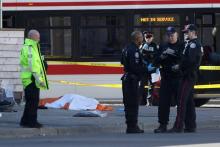 Des policiers près d'un corps caché par un drap, le 23 avril 2018 à Toronto, au Canada, après qu'un homme au volant d'une camionnette a fauché une dizaine de piétons