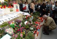 A Londres le 16 avril 2018, des personnes rassemblées devant l'ambassade de Malte brandissent des photos de la journaliste maltaise assassinée Daphne Caruana Galizia