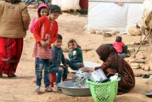 Une femme et des enfants syriens dans un camp de réfugiés dans la plaine de la Bekaa, le 8 mars 2018 au Liban