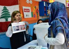 Une responsable du bureau de vote explique la procédure à une électrice libanaise, à Abidjan le 29 avril 2018