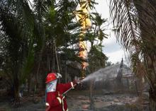 Un pompier indonésien combat l'incendie d'un puits de pétrole illégal à Peureulak, le 25 avril 2018
