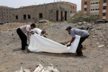Des Yéménites enveloppent le corps d'une victime tuée lors d'une frappe aérienne, le 2 avril 2018 à Hodeida