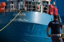 Un policier italien se tient près du navire Iuventa de l'ONG allemande Jugend Rettet dans le port de Trapani le 4 août 2017