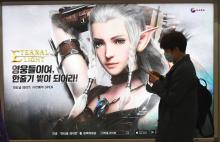 Un homme passe devant une affiche publicitaire pour un jeu vidéo, le 9 avril 2018 dans le métro de Séoul
