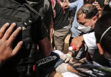 Des Palestiniens tentent de secourir le journaliste Yasser Mourtaja blessé par les forces de sécurité israéliennes lors d'une manifestation à la frontière de Gaza, à l'est de Khan Younès, le 6 avril 2