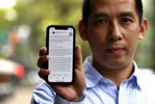 Un militant vietnamien montre la lettre ouverte à Facebook sur l'écran de son smartphone, le 10 avril 2018