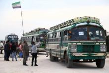 Des bus de combattants du groupe Jaich al-Islam et leurs familles en provenance du bastion rebelle de Douma arrivent au poste de contrôle d'Abu al-Zindeen près de la ville syrienne d'al-Bab, dans le n