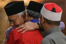 L'ancien Premier ministre de Malaisie Najib Razak (G) donne l'accolade à son ancien adjoint Ahmad Zahid Hamidi (C) avant la grande prière du vendredi, à Kuala Lumpur le 18 mai 2018