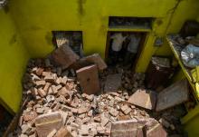 Des voisins regardent le plafond qui s'est effondré sur Sunil Kumar, 24 ans, lors d'une tempête à Kheragarh dans les environs d'Agra, en Inde le 4 mai 2018.