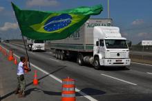 Un transporteur routier agite le drapeau brésilien devant la raffinerie de Duque de Caxias près de Rio de Janeiro, le 28 mai 2018