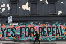 Un homme passe devant un graffiti appelant à voter "Oui", au référendum sur l'avortement en Irlande, à Dun Laoghaire, le 10 mai 2018