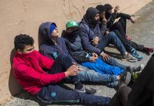 De jeunes Marocains sont assis contre un mur dans le port de Ceuta, une enclave espagnole dans le nord du Maroc, le 11 avril 2018