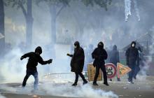 Un casseur lance une pierre vers les forces de l'ordre en marge du défilé du 1er mai 2018 à Paris