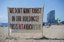 "Nous ne voulons pas de touristes dans nos immeubles, ceci n'est pas une station balnéaire", indique cette bannière sur la plage de La Barceloneta, en août 2017
