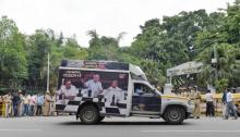 Un véhicule arborant une affiche illustrant la partie d'échecs politique en cours au Karnataka passe devant la résidence du gouverneur de l'Etat à Bangalore en Inde le 16 mai 2018