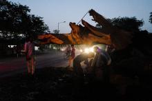 Des Indiens tronçonnent un arbre tombé en travers d'une route lors d'une tempête, le 3 mai 2018 à Agra