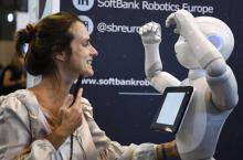 Une femme joue avec Pepper, un robot humanoïde fabriqué par SoftBank Robotics et exposé au salon Vivatech à Paris, le 24 mai 2018