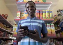 Amadou Bousso, épicier et utilisateur de l'application Weebi qui facilite la gestion comptable des petits commerçants, dans son magasin de Dakar (Sénégal) le 23 mars 2017