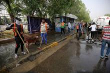 Des employés municipaux nettoient les lieux d'un attentat-suicide contre des cafés, dans le quartier majoritairement chiite d'al-Shoala, le 24 mai 2018 à Bagdad
