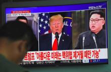 Les photos du président américain Donald Trump (g) et du leader nord-coréen Kim Jong Un sur un écran de télévision dans une gare de Séoul, le 25 mai 2018, après l'annulation du sommet entre les deux d