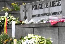 Un policier s'entretient avec des parents d'élèves d'un groupe scolaire à Liège (Belgique) proche du site d'une attaque qui a fait 3 morts dont deux policières, le 29 mai 2018