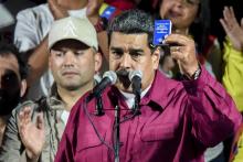 Nicolas Maduro tient un exemplaire de la Constitution vénézuélienne, après sa victoire à la présidentielel, le 20 mai 2018 à Caracas