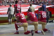 Les joueurs de San Francisco Eric Reid, Colin Kaepernick et Eli Harold, genou à terre, lors de l'hymne américain avant un match contre la Nouvelle-Orléans, le 6 novembre 2016 à Santa Clara, en Califor