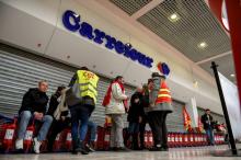 Des employés devant un supermarché de l'enseigne Carrefour à Lomme le 31 mars 2018