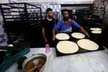 Des boulangers préparent du pain sucré dans la ville syrienne de Raqa, le 17 mai 2018, pendant le mois sacré du ramadan