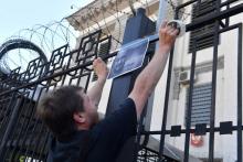 Un militant accroche des photos d'Arkadi Babchenko devant l'ambassade de Russie à le 30 mai 2018