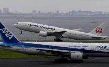 Un Boeing 777 de Japan Airlines (JAL) au décollage près d'un avion de All Nippon Airways (ANA) à l'aéroport international Haneda de Tokyo, le 2 août 2017