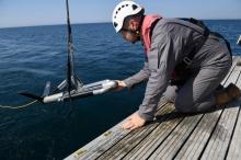Un agent du ministère de la Culture place un sonar au large de Brest à la recherche de l'épave de La Cordeliere et du Regent, le 29 juin 2018