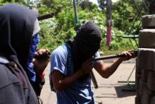 Des manifestants anti-gouvernement se protègent derrière une barricade à Masaya, une ville à 35 km de la capitale du Nicaragua Managua, le 20 juin 2018