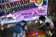 Des membres de la communauté LGBT allument des bougies lors d'un rassemblement devant la Cour suprême des Philippines qui doit examiner les arguments en faveur du mariage gay, le 19 juin 2018 à Manill