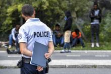 Des migrants face à un policier près du port de Calais, le 16 août 2017