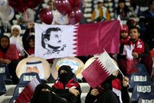 Des spectateurs d'un match de football au Qatar brandissent le drapeau national avec l'effigie de l'émir cheikh Tamim ben Hamad Al-Thani, prise le 23 décembre 2017 au Koweït