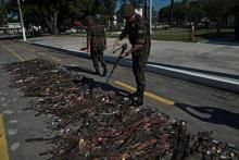 Des armes saisies lors d'opérations contre les groupes criminels sont inspectées à Rio le 20 juin 2018 après leur destruction.