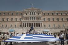 Le drapeau grec déployé devant le Parlement lors d'une manifestation contre les réformes du gouvernement, le 14 juin 2018 à Athènes