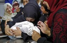 La mère de Leila al-Ghandour (C), un bébé palestinien de huit mois mort lundi après avoir inhalé des gaz lacrymogènes tirés par l'armée israélienne selon le ministère de la Santé à Gaza, tient le corp