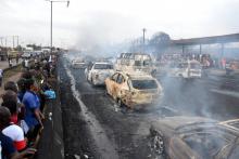 Des passants observent les ravages causés par l'incendie déclenché par l'explosion d'un camion-citerne à Lagos le 28 juin 2018.