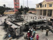 Photographie prise le 12 juin 2018 montrant des carcasses de bus incendiés au Vietnam devant un poste de police dans la province de Binh Thuan (sud) deux jours après une violente manifestation contre 