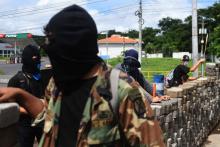 Des étudiants munis d'armes artisanales derrière une barricade, le 23 juin 2018 à Managua, au Nicaragua