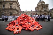 Un collectif de bénévoles d'aide aux migrants a déversé des gilets de sauvetage devant le Sénat pour alerter sur les naufrages en mer et protester contre le projet de loi asile-immigration, le 19 juin