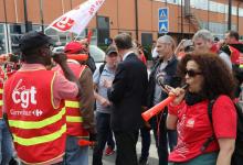 Un actionnaire quittant l'assemblée générale de Carrefour le 15 juin 2018 à Aubervilliers (Seine-Saint-Denis)parle avec des syndicalistes CGT